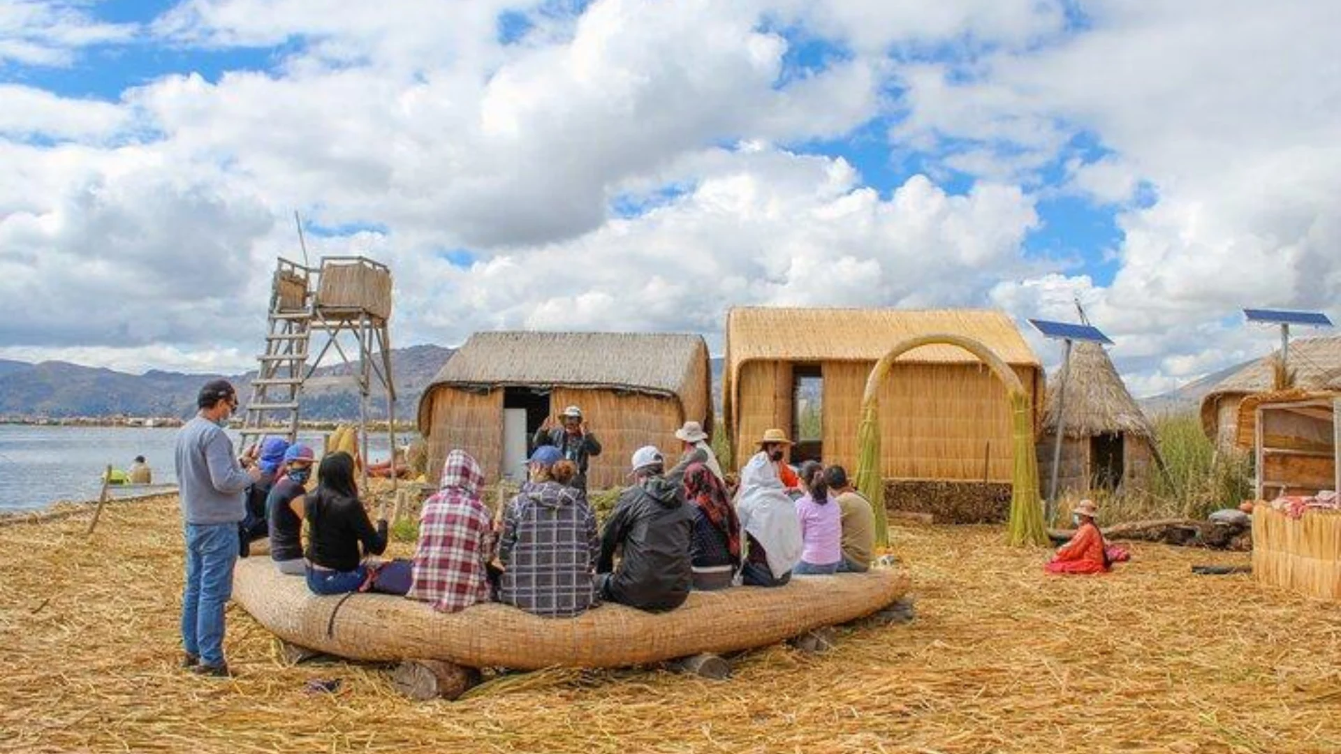 Travelers learning from a local Uros guide on Lake Titicaca