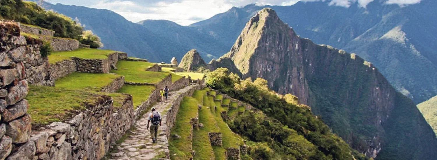 Scenic descent from the Sun Gate (Inti Punku) toward Machu Picchu with panoramic views of the citadel and surrounding mountains