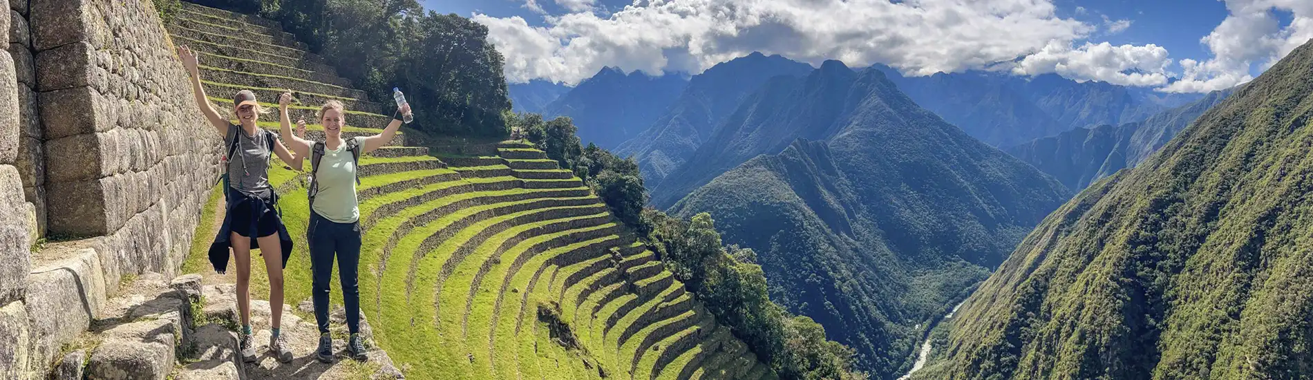 Two happy tourists enjoying the stunning mountain scenery at Wiñay Wayna on the Inca Trail in Peru