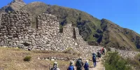 Turistas llegando al sitio arqueológico de Patallacta durante el primer día del Camino Inca 4 días 3 noches, rodeados de terrazas incas y paisajes del Valle Sagrado en Cusco, Perú