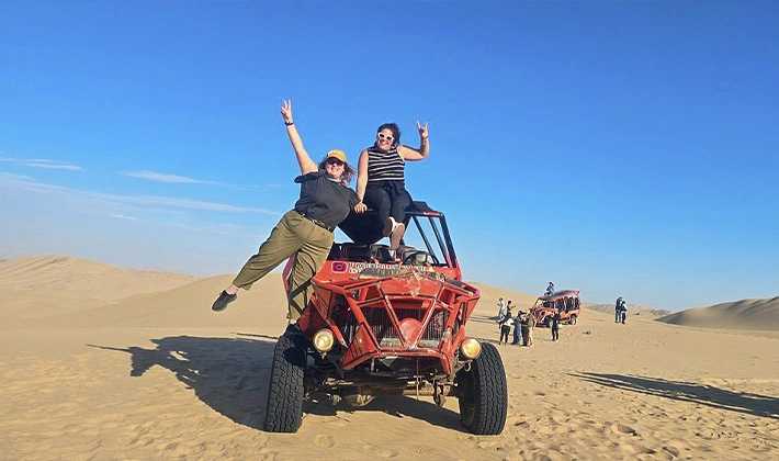 Travelers enjoying an exciting buggy ride on the dunes of Huacachina Oasis in Ica, Peru.