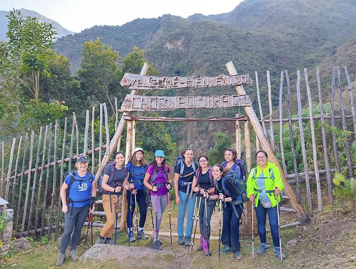 Group of tourists at the entrance of the Choquequirao trekking trail in the Andes of Peru, ready to start their hike